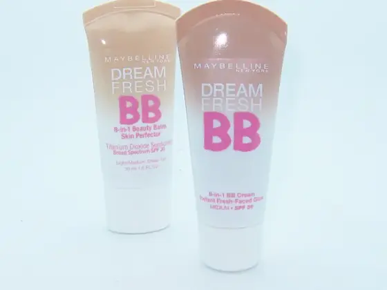 Main appliquant une BB crème par petites touches sur une joue avec le bout des doigts