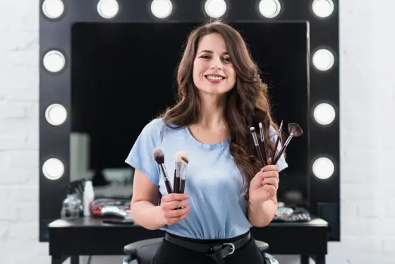 Personne appliquant un fond de teint léger au pinceau sur une joue devant un miroir