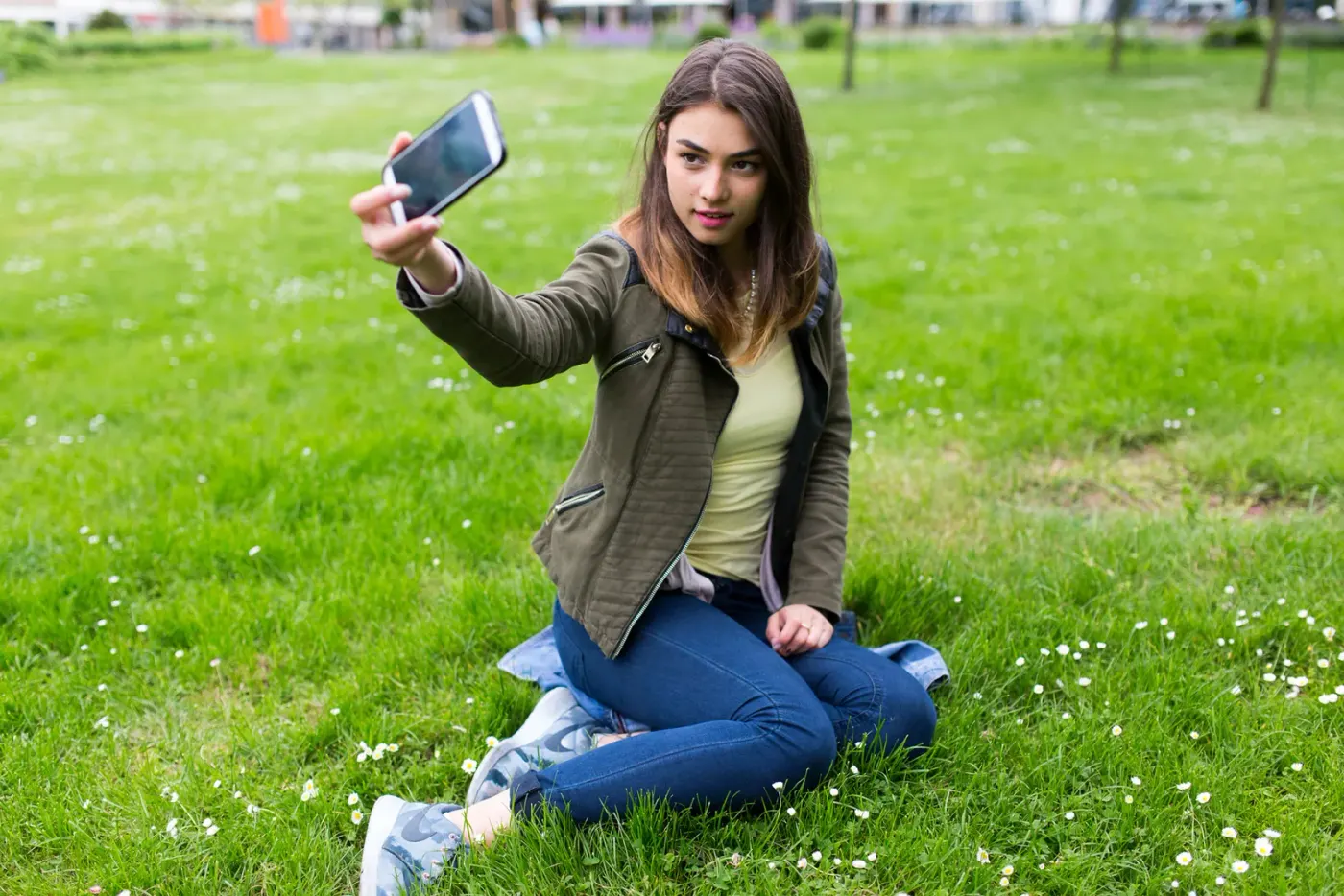 Personne photographiant l’arrière de sa coupe au téléphone devant une fenêtre