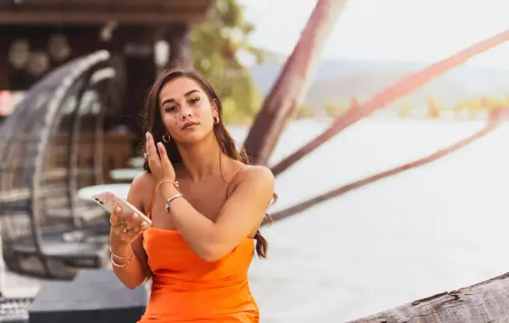 Personne appliquant un voile de teint léger sur une peau protégée du soleil en extérieur