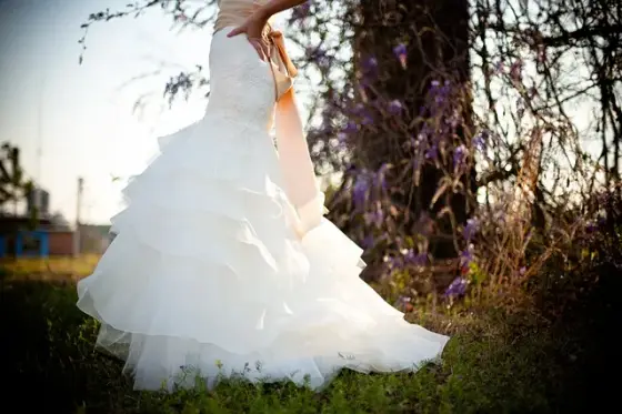 Personne essayant une robe ivoire devant un miroir, accompagnée d’une proche
