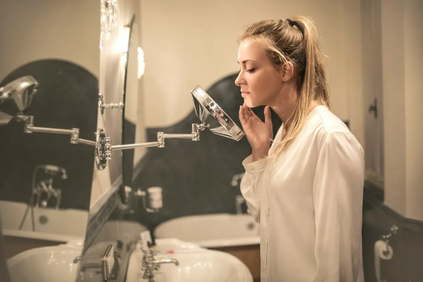 Flacons de soin sans parfum, gel d’aloe vera et serviette propre posés près d’un lavabo