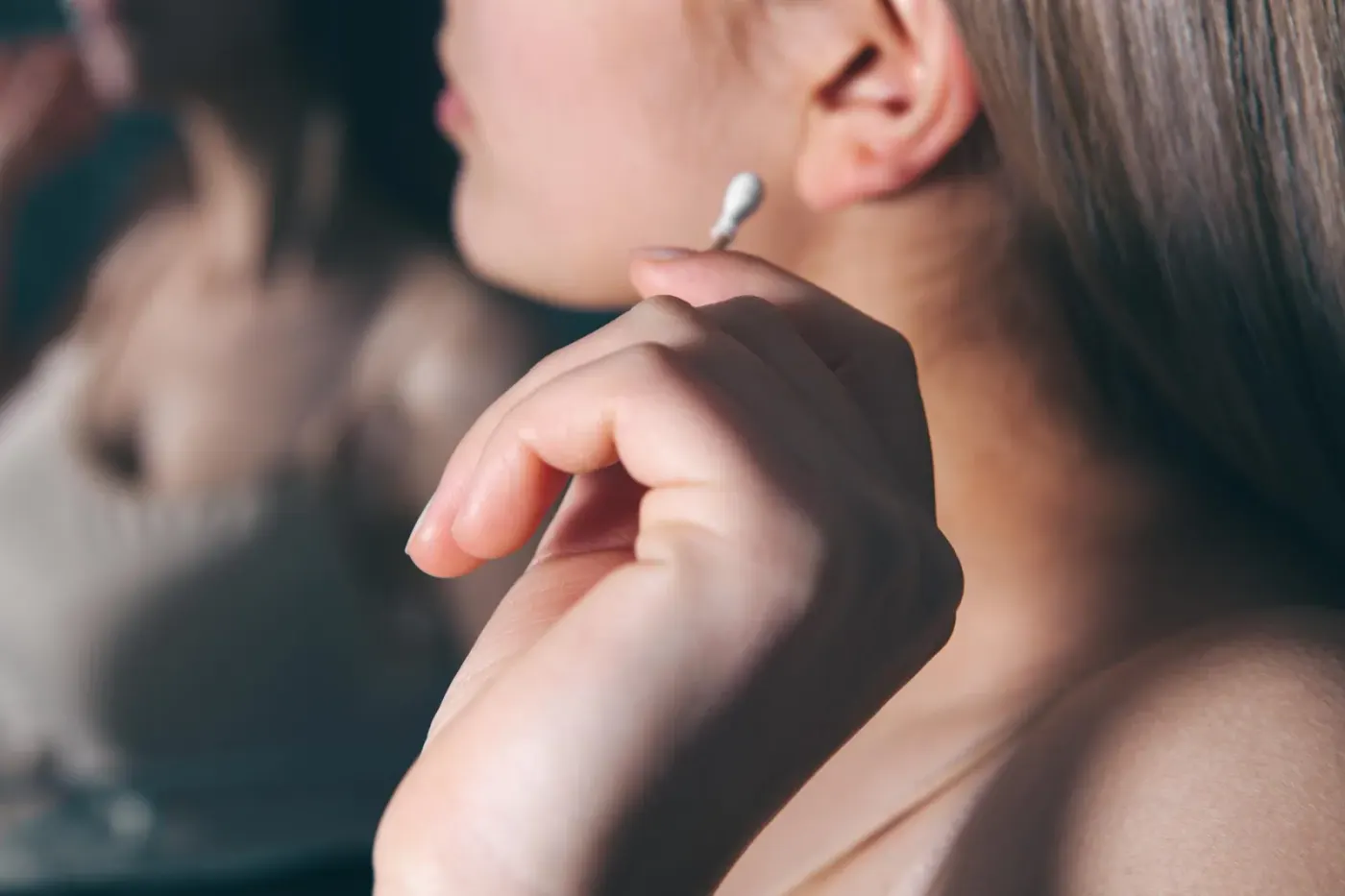 Personne séchant délicatement le pavillon de son oreille avec une serviette propre